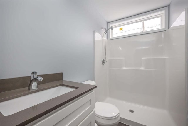 bathroom featuring a shower, vanity, and toilet