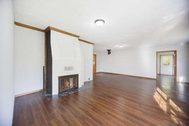 unfurnished living room with dark hardwood / wood-style flooring, a brick fireplace, and ornamental molding