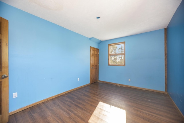 unfurnished room with dark wood-type flooring