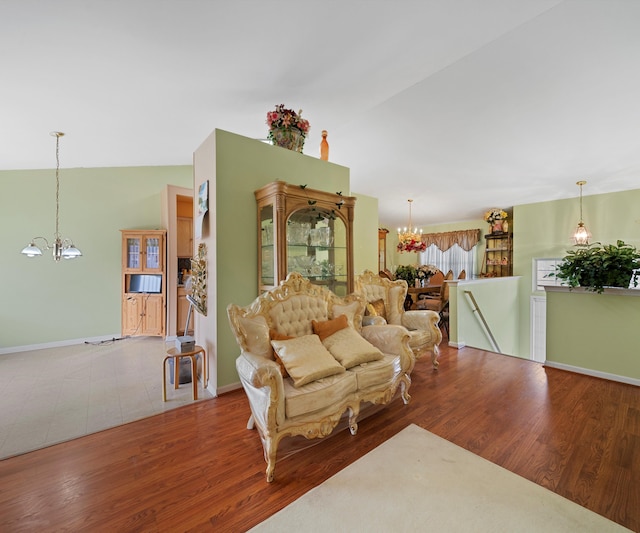 living room with hardwood / wood-style flooring, lofted ceiling, and a chandelier