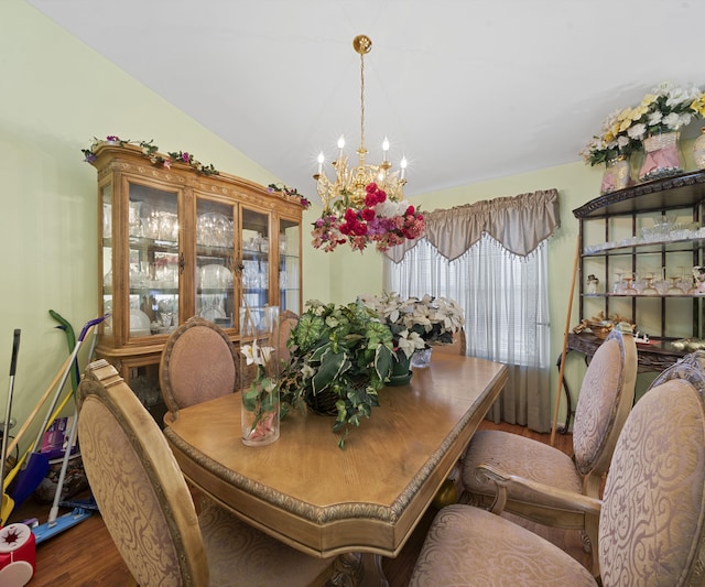 dining space featuring lofted ceiling, dark wood-type flooring, and a notable chandelier