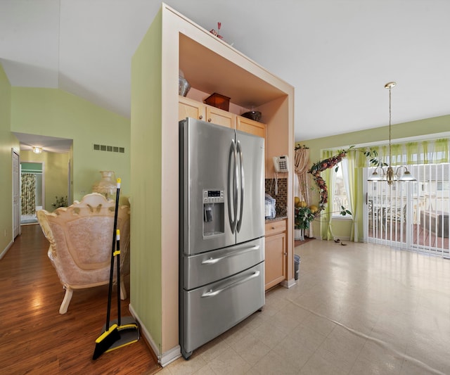 kitchen featuring pendant lighting, lofted ceiling, an inviting chandelier, stainless steel refrigerator with ice dispenser, and light brown cabinetry