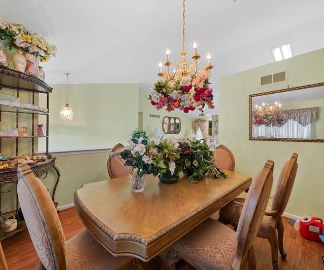 dining area featuring wood-type flooring and a chandelier