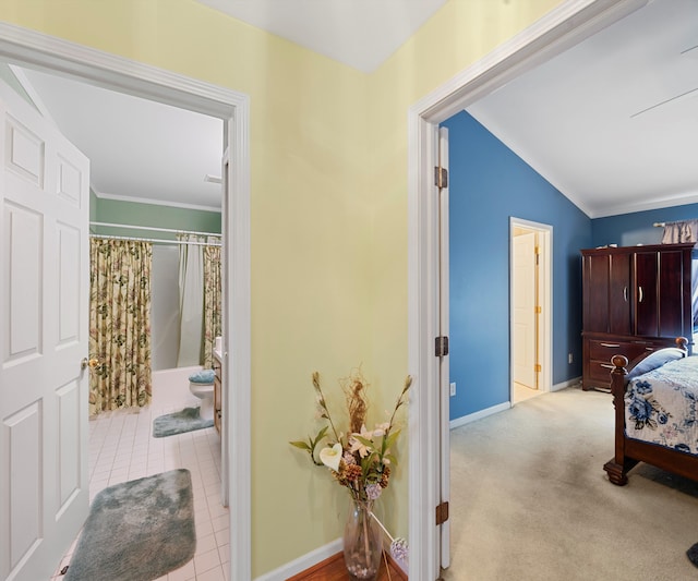 bedroom with lofted ceiling, ornamental molding, and light carpet