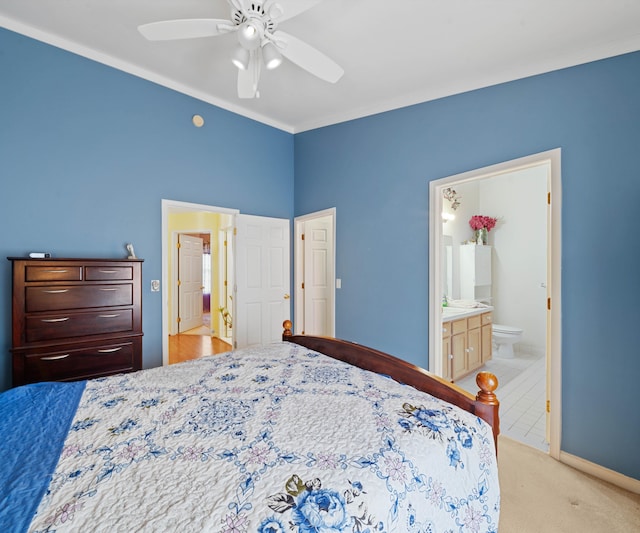 carpeted bedroom with connected bathroom, ceiling fan, and crown molding