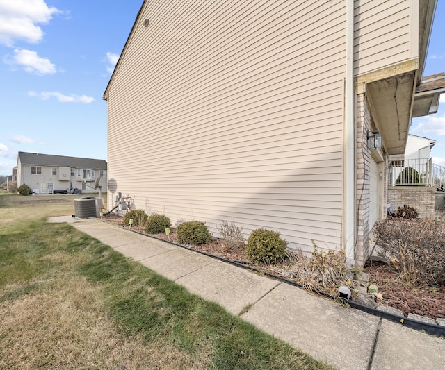 view of home's exterior featuring a lawn and central AC