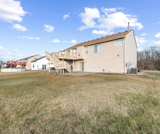 rear view of property featuring a lawn, a patio area, central AC, and a deck