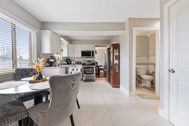 dining area featuring sink and light tile patterned flooring