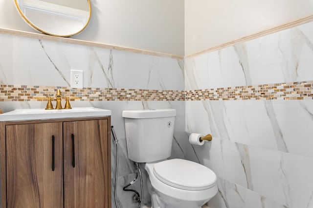 bathroom with backsplash, vanity, tile walls, and toilet