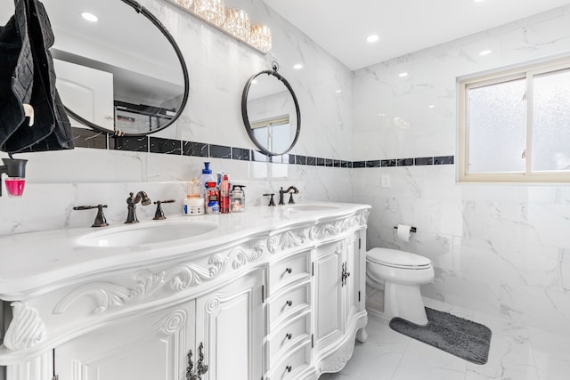 bathroom featuring vanity, toilet, and tile walls