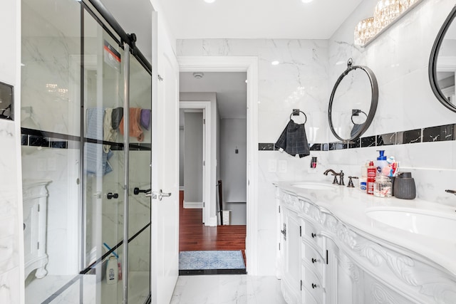 bathroom featuring vanity, a shower with shower door, and tile walls