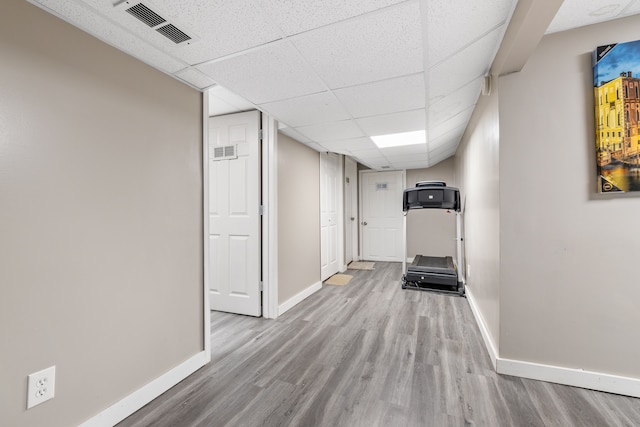 hall featuring a paneled ceiling and light hardwood / wood-style floors