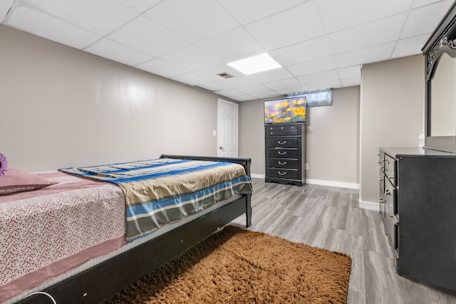 bedroom with light hardwood / wood-style flooring and a drop ceiling