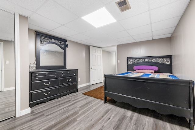 bedroom featuring a paneled ceiling and hardwood / wood-style flooring