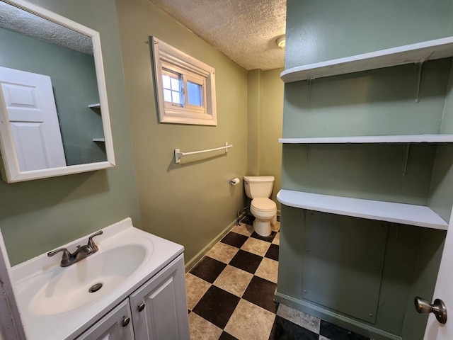bathroom featuring vanity, toilet, and a textured ceiling