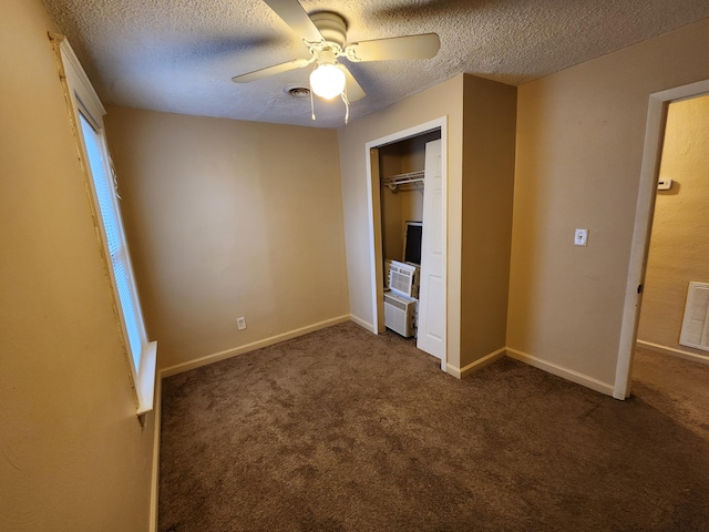 unfurnished bedroom featuring ceiling fan, cooling unit, a textured ceiling, a closet, and dark carpet