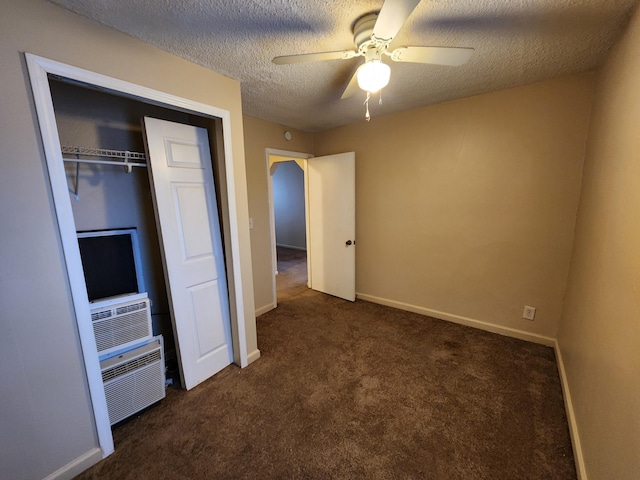 unfurnished bedroom featuring a textured ceiling, ceiling fan, cooling unit, dark colored carpet, and a closet