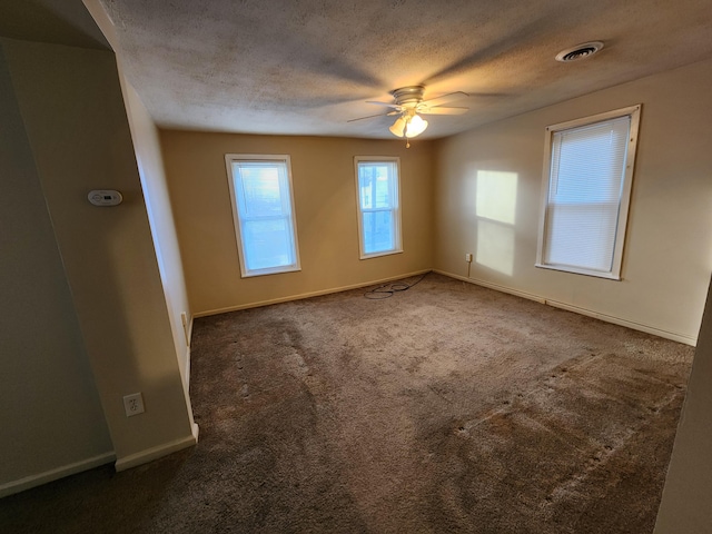 carpeted empty room featuring a textured ceiling and ceiling fan