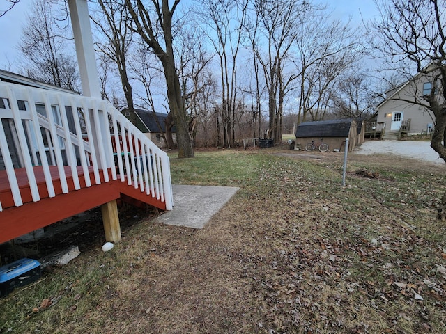 view of yard featuring a storage unit and a deck