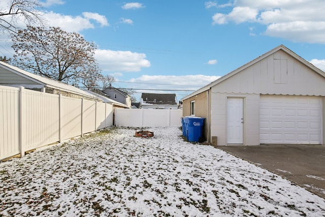 snowy yard featuring a garage