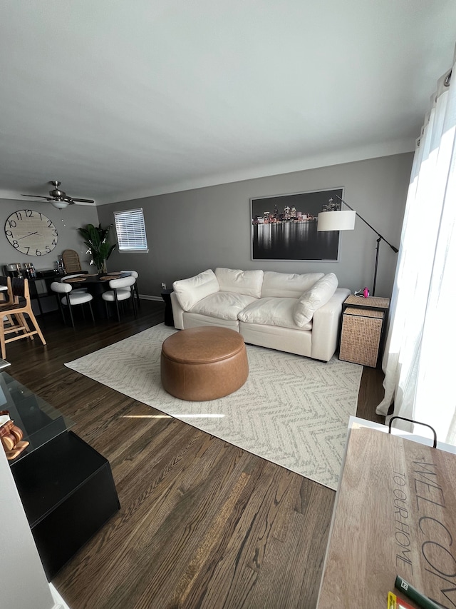 living room with ceiling fan and dark wood-type flooring