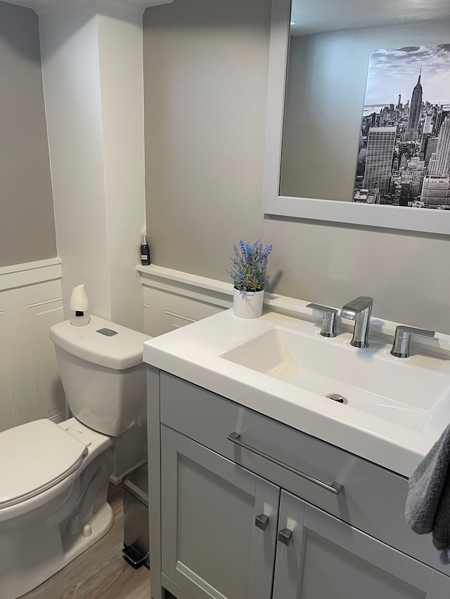 bathroom featuring toilet, wood finished floors, and vanity