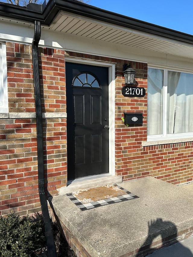 entrance to property featuring brick siding