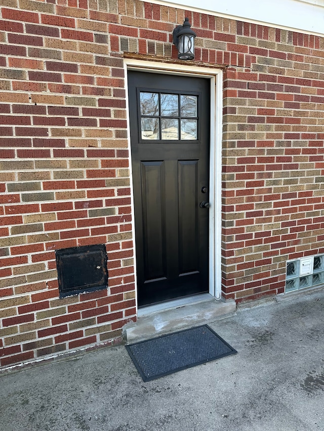 view of exterior entry with brick siding