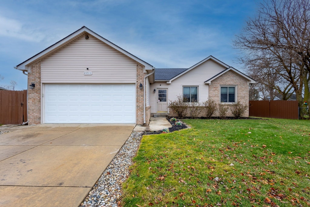 ranch-style house featuring a garage and a front yard