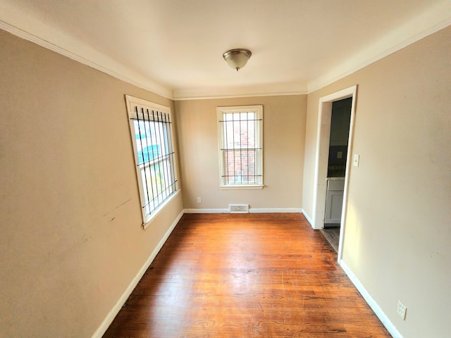 unfurnished room with crown molding and hardwood / wood-style floors