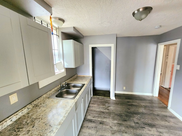 kitchen featuring white cabinets, dark hardwood / wood-style flooring, sink, and a textured ceiling