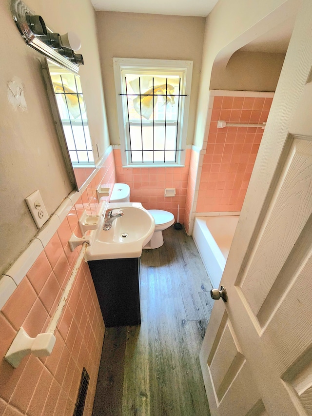 bathroom featuring toilet, vanity, tile walls, and hardwood / wood-style floors