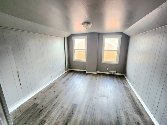 additional living space featuring vaulted ceiling and hardwood / wood-style floors