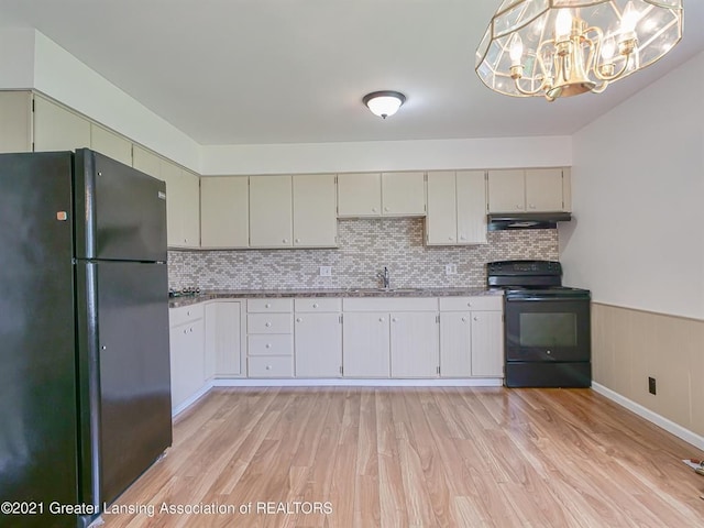 kitchen featuring hanging light fixtures, tasteful backsplash, a notable chandelier, black appliances, and light wood-type flooring