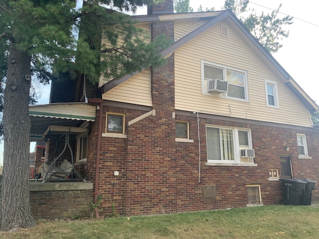 view of home's exterior with cooling unit and a lawn