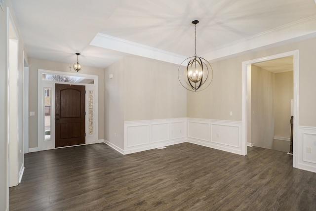 entrance foyer with dark hardwood / wood-style floors, crown molding, and a chandelier