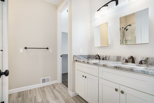 bathroom featuring wood-type flooring, vanity, and walk in shower