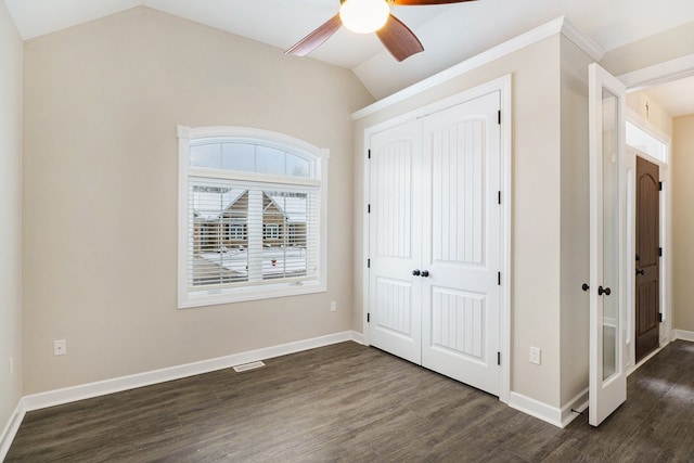 unfurnished bedroom featuring dark wood-type flooring, a closet, lofted ceiling, and ceiling fan