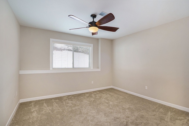 carpeted spare room featuring ceiling fan