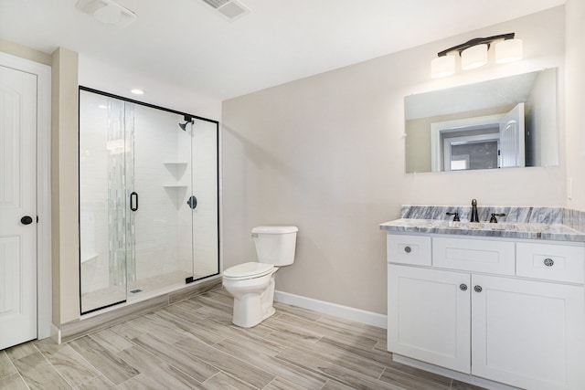 bathroom featuring vanity, toilet, and an enclosed shower