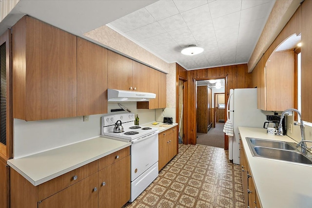 kitchen with sink, wooden walls, and white range with electric stovetop