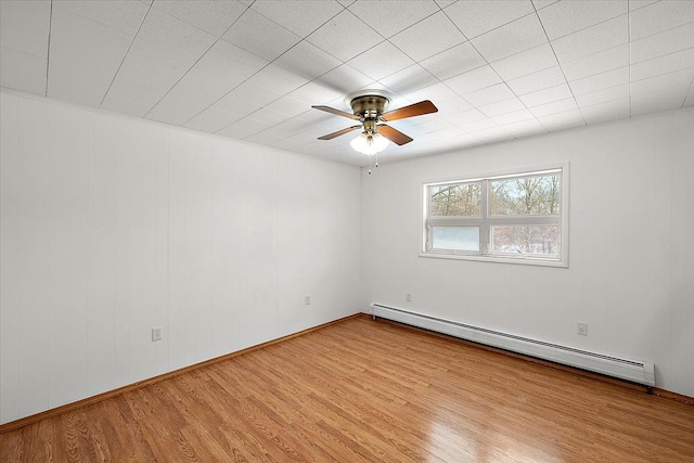 spare room with ceiling fan, baseboard heating, and light hardwood / wood-style floors