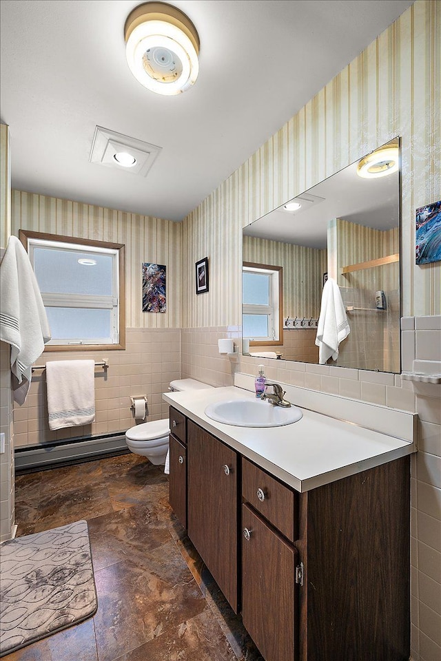 bathroom with toilet, vanity, and a baseboard heating unit