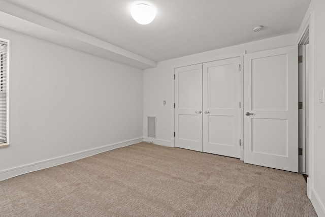 unfurnished bedroom with a closet and light carpet