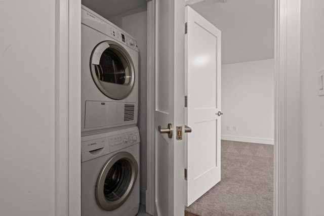 laundry area featuring light colored carpet and stacked washing maching and dryer