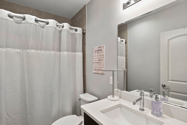 bathroom featuring toilet, vanity, and walk in shower