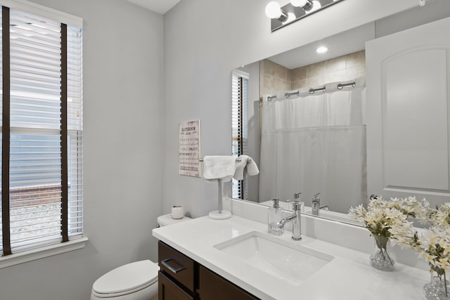 bathroom with plenty of natural light, vanity, and toilet