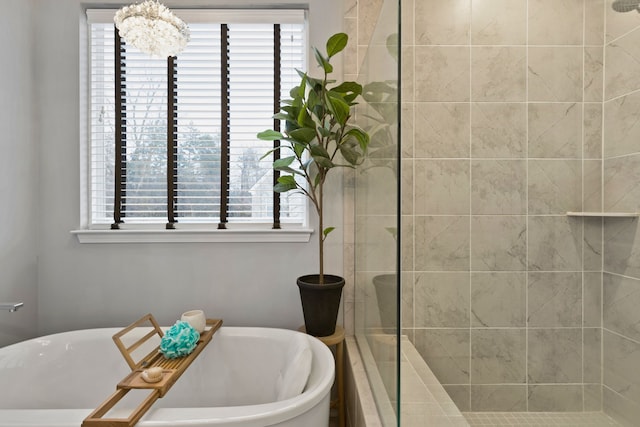 bathroom with separate shower and tub and an inviting chandelier