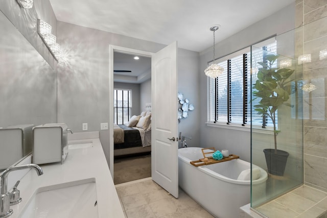 bathroom with plenty of natural light, a bathtub, and a notable chandelier