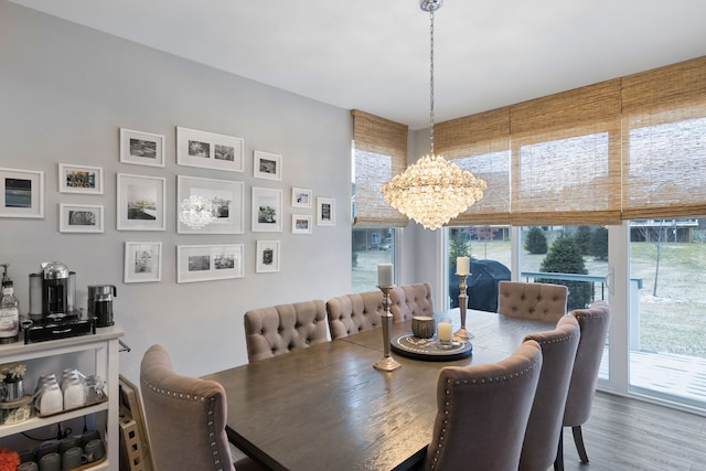 dining area with wood-type flooring and a notable chandelier